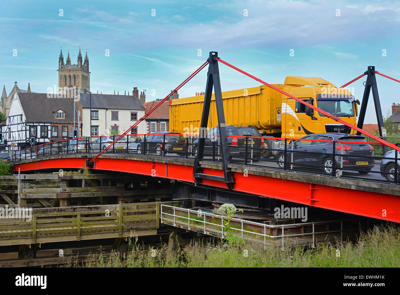 Il traffico che attraversa selby ponte girevole sul fiume Ouse con selby abbey nella distanza Yorkshire Regno Unito Foto Stock