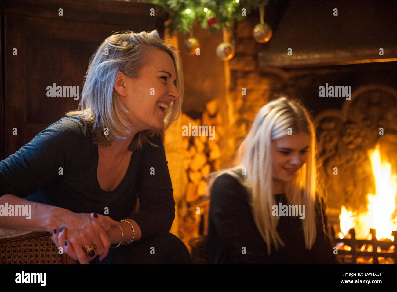 La scena di una famiglia attorno a un fuoco aperto il giorno di Natale Foto Stock