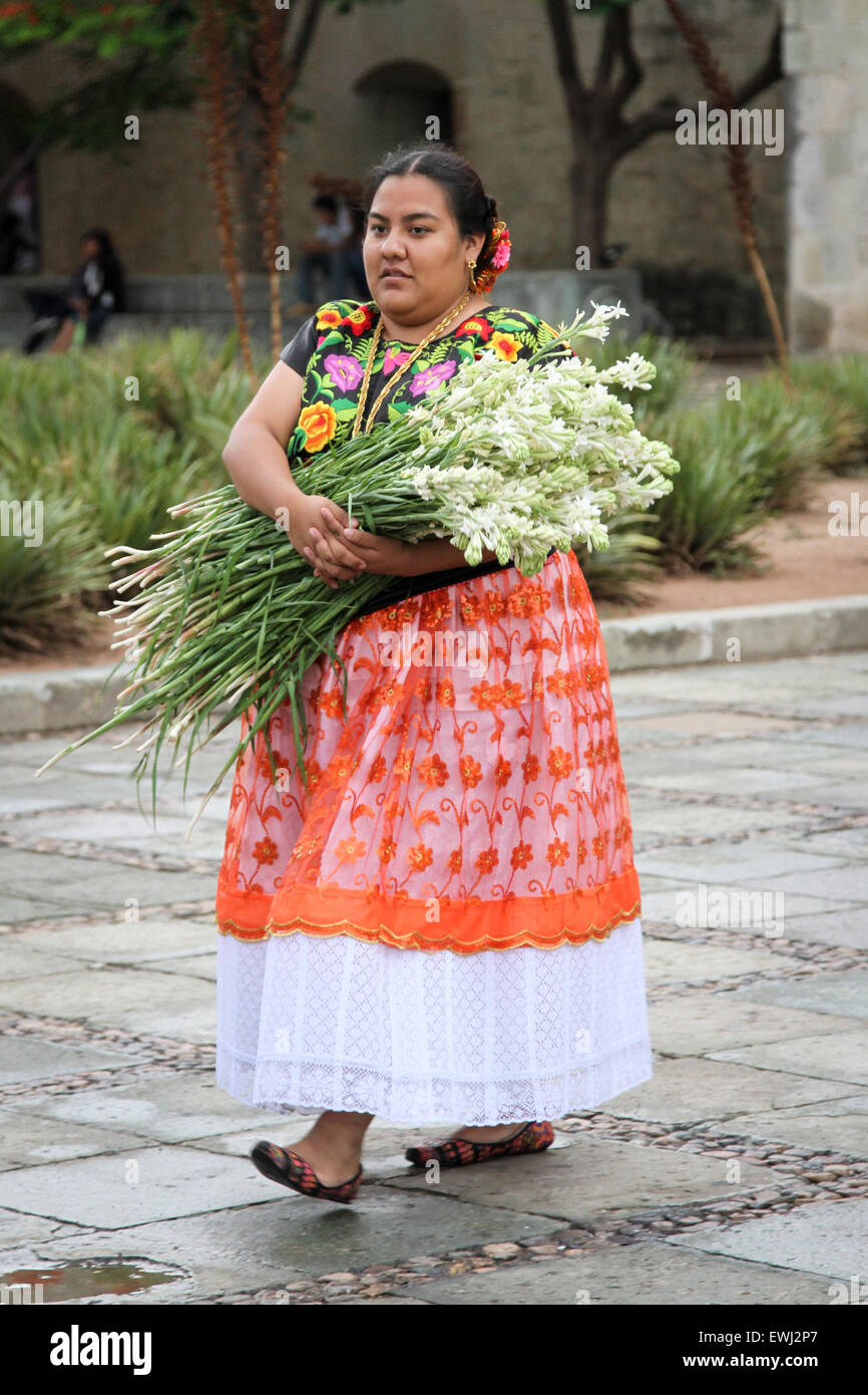 Donna messicana in costume tradizionale portando un grosso mazzo