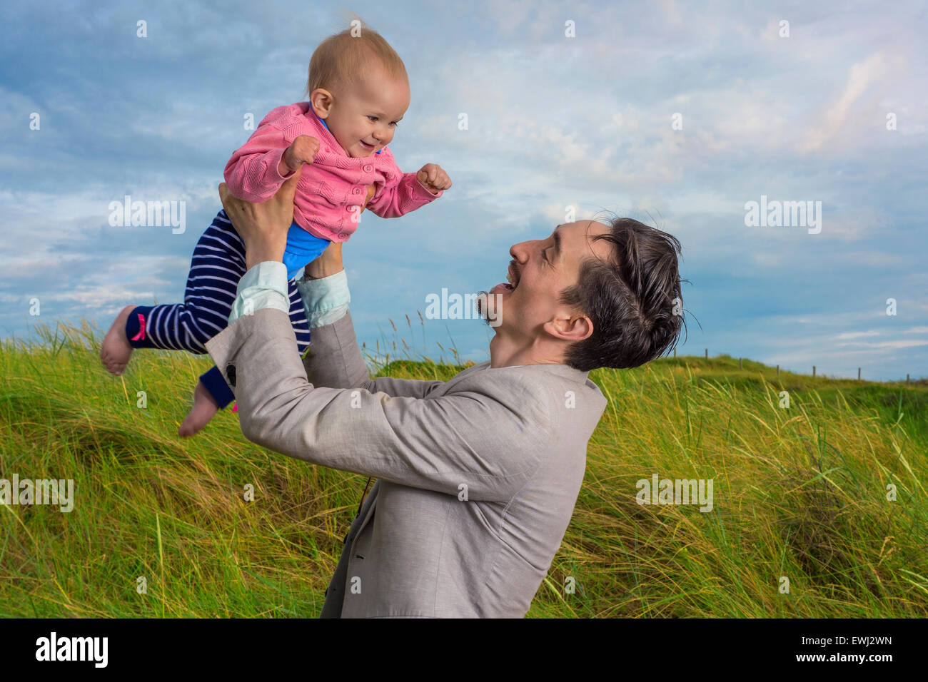 Padre tenendo la sua bimba in aria in alto Foto Stock