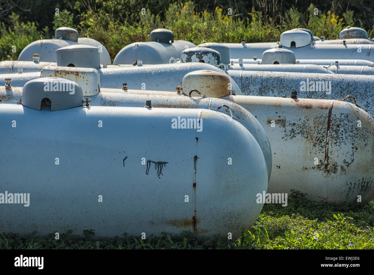 Utilizzato propano serbatoi di stoccaggio ruggine in un campo. Foto Stock