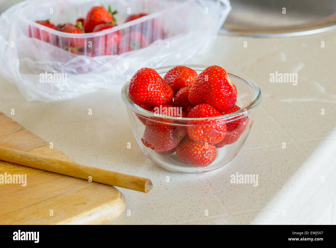 Preparazione di rosso naturale le fragole in un bicchiere di vetro, in cucina vicino al lavandino Foto Stock