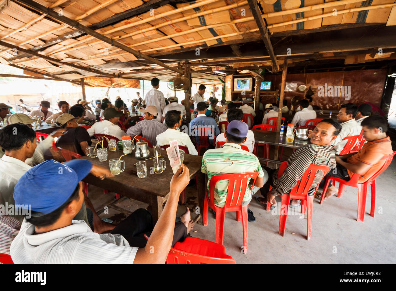 I cambogiani guarda e scommesse sul match di boxe in un villaggio rurale shop. Foto Stock