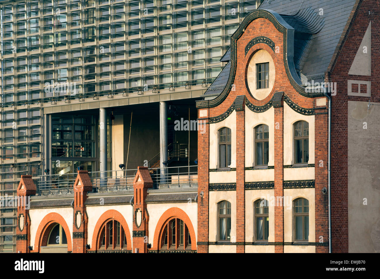Il vecchio edificio in mattoni rossi in parte anteriore del moderno edificio di vetro muro di Berlino Foto Stock