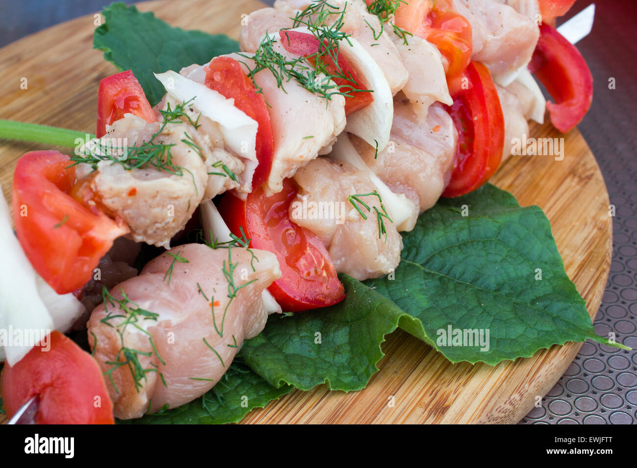 Infilzato su bastoni di legno gustosi piatti a base di carne di maiale e mix di verdure spiedini preparati per grigliare sulla piastra Foto Stock