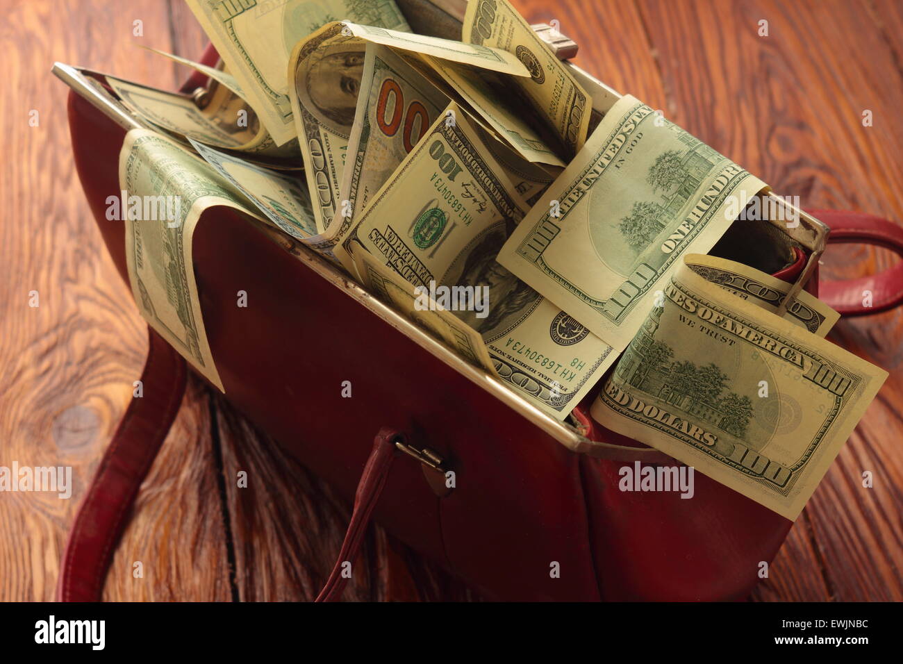 Su una tavola di legno borsa piena di denaro Foto Stock