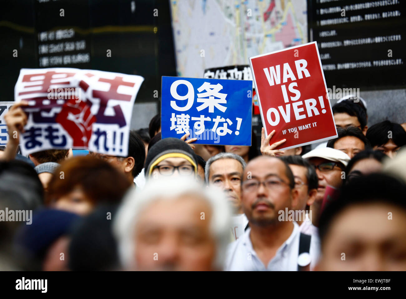 I membri di studenti azione di emergenza per la democrazia liberale-s (SEALDs) chiamata per la protezione del pacifista di articolo 9 della Costituzione giapponese in Shibuya quartiere dello shopping a giugno 27, 2015, Tokyo, Giappone. Circa mille persone hanno manifestato davanti alla famosa intersezione al di fuori della stazione di Shibuya contro il Primo Ministro Abe reinterpretazione dell articolo 9 che consentirebbe la nazione, le truppe per la lotta all'estero. © Rodrigo Reyes Marin/AFLO/Alamy Live News Foto Stock