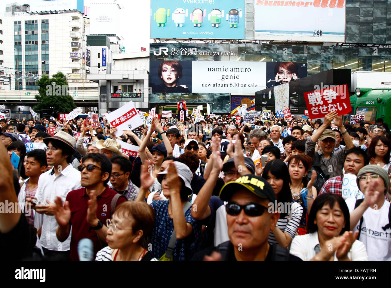 I membri di studenti azione di emergenza per la democrazia liberale-s (SEALDs) chiamata per la protezione del pacifista di articolo 9 della Costituzione giapponese in Shibuya quartiere dello shopping a giugno 27, 2015, Tokyo, Giappone. Circa mille persone hanno manifestato davanti alla famosa intersezione al di fuori della stazione di Shibuya contro il Primo Ministro Abe reinterpretazione dell articolo 9 che consentirebbe la nazione, le truppe per la lotta all'estero. © Rodrigo Reyes Marin/AFLO/Alamy Live News Foto Stock