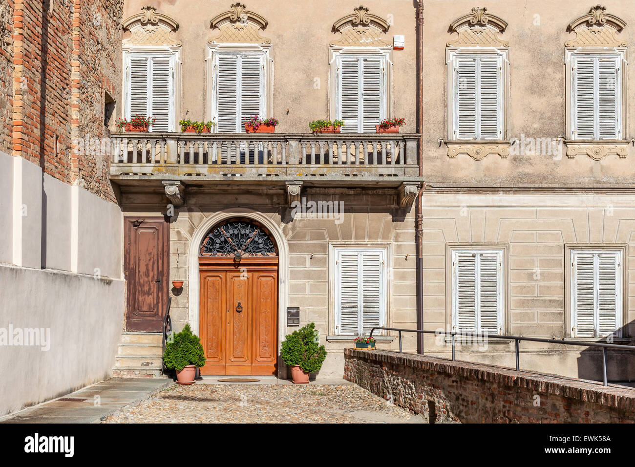 La facciata della tipica casa italiana con balcone e porta di legno nella città di La Morra in Piemonte, Italia settentrionale. Foto Stock