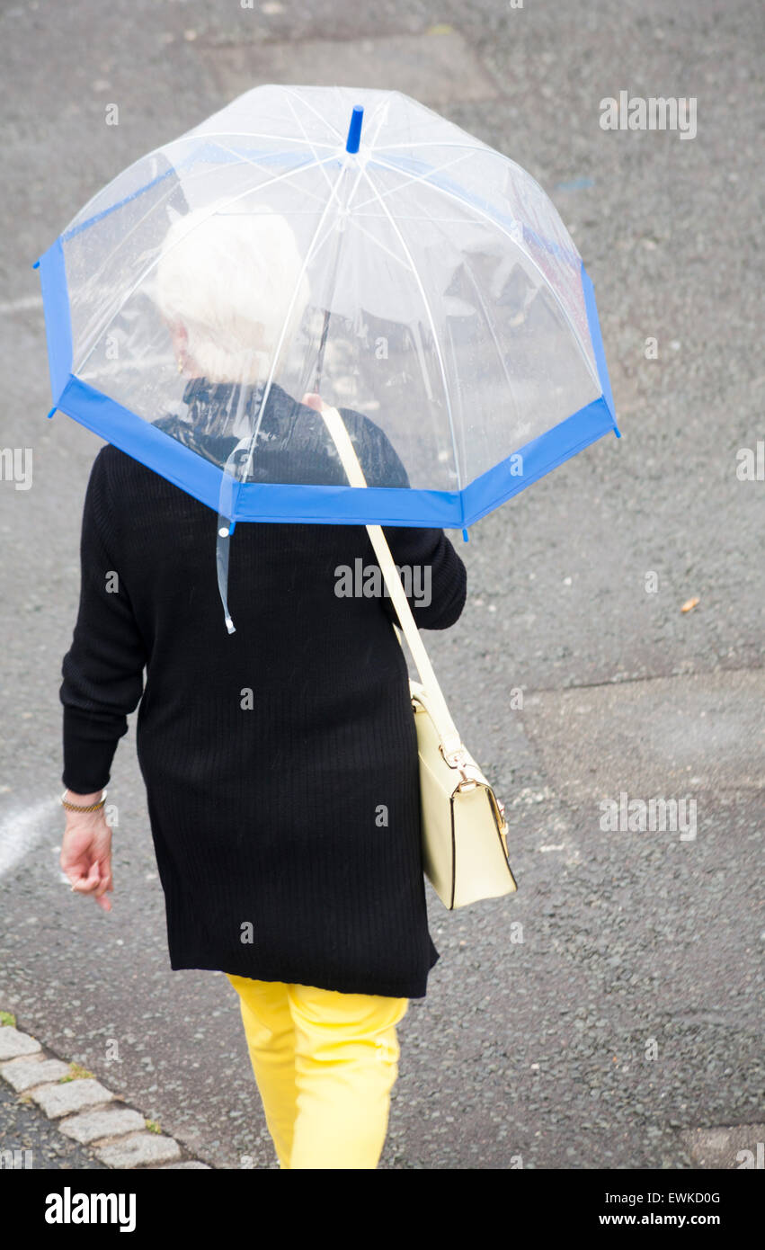 Poole, Dorset, Regno Unito. Il 28 giugno, 2015. Regno Unito: meteo Umido bagnato per iniziare la giornata a Poole - donna ripari sotto ombrellone Credito: Carolyn Jenkins/Alamy Live News Foto Stock