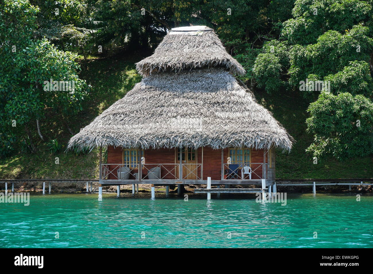 Bungalow Overwater con tetto di paglia sulla costa Caraibica di Panama, America Centrale Foto Stock