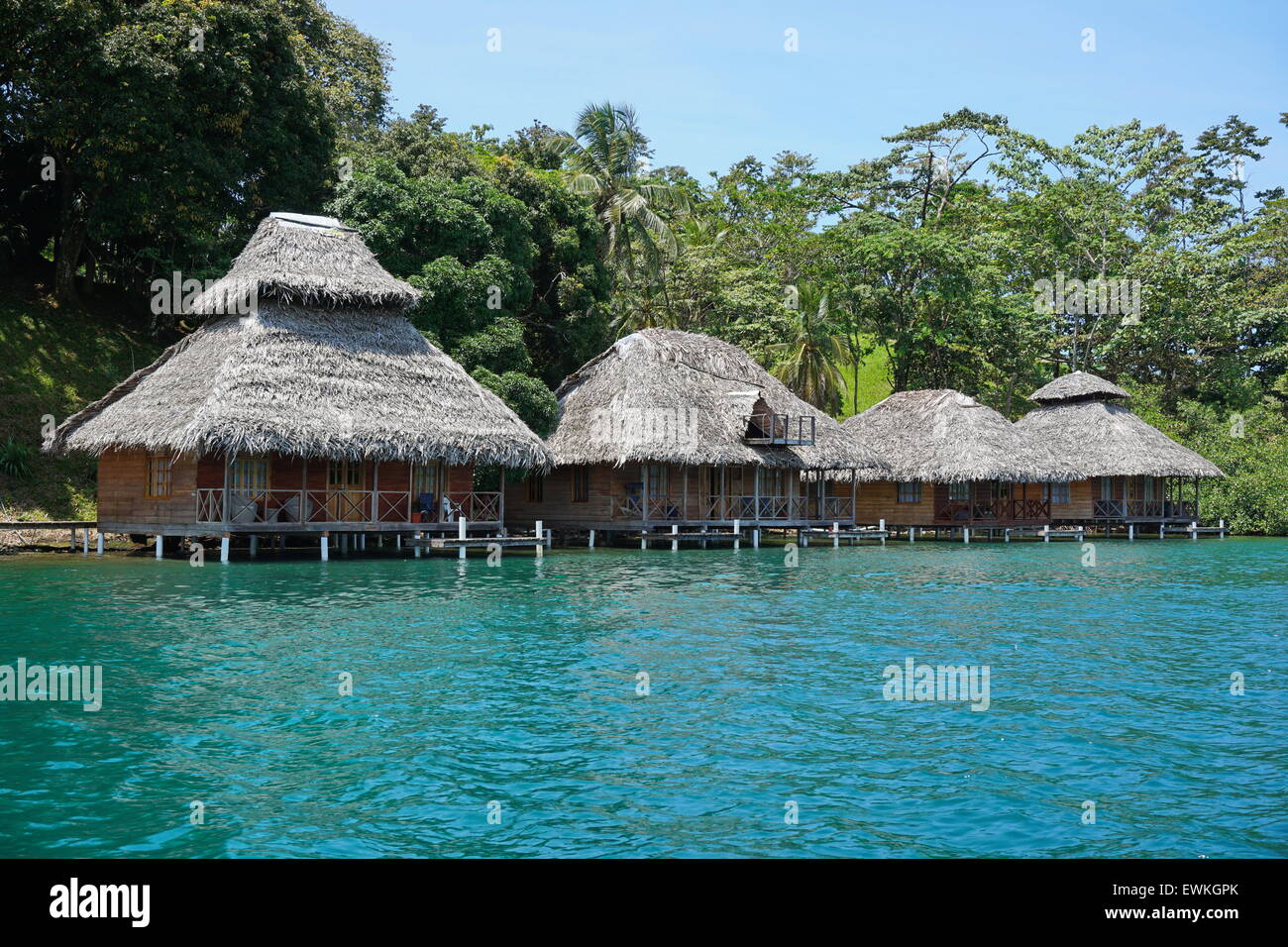 Tropical eco resort con bungalow con tetto in paglia per l'acqua del mare dei Caraibi a Panama, Bocas del Toro, America Centrale Foto Stock