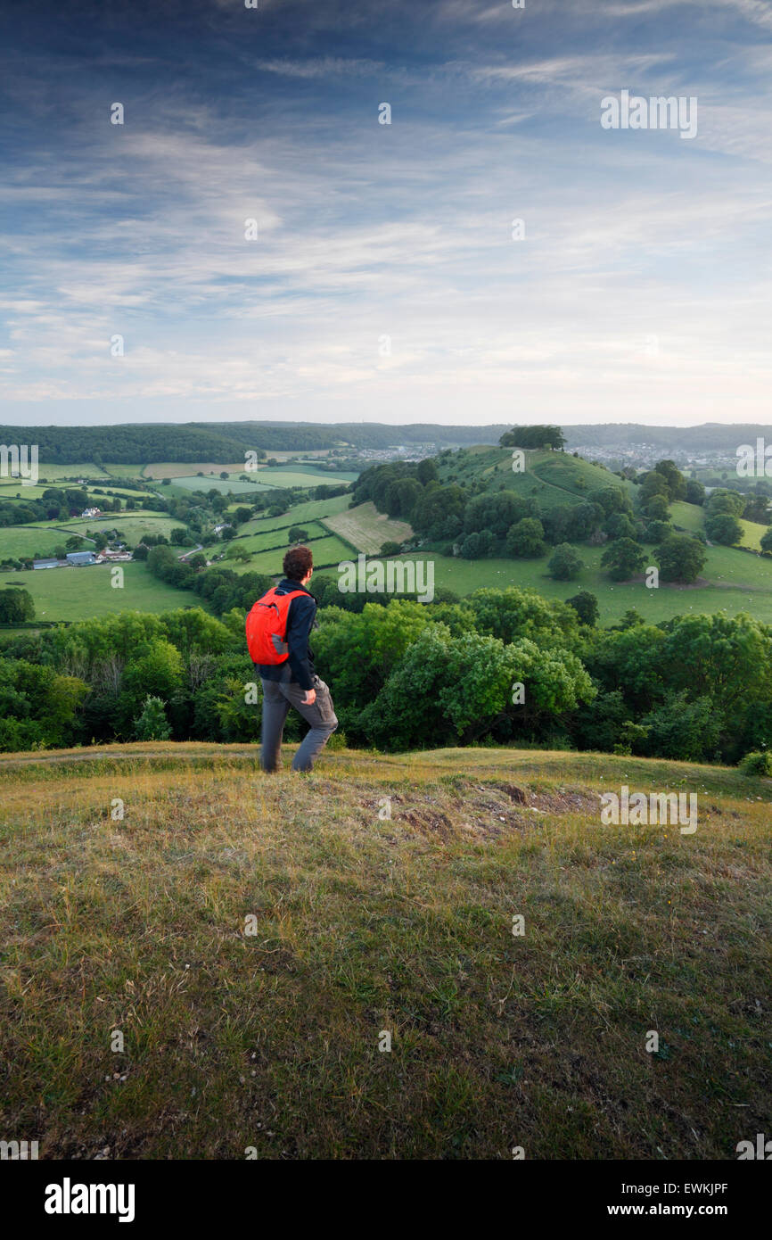 Walker su Uley Bury, guardando la vista verso Downham Hill. Il Cotswolds. Gloucestershire. Regno Unito. Una breve deviazione dal Cotsw Foto Stock