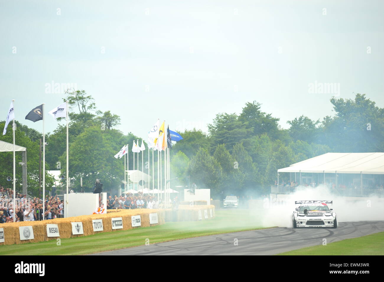 Una vettura fa un sacco di fumo dei pneumatici al Festival di Goodwood di velocità. Racing driver, celebrità e migliaia di membri del pubblico hanno partecipato al Festival di Goodwood di velocità per vedere il vecchio e moderno racing auto e moto in azione. Foto Stock