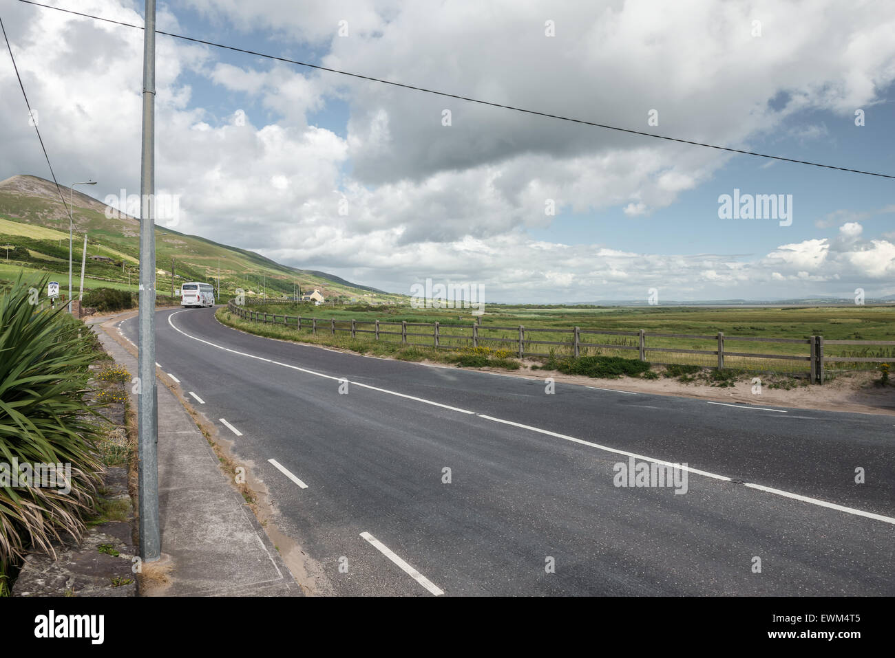 Paesaggio rurale irlandese con autobus lontano sulla strada a Inch Beach, County Kerry, Irlanda Foto Stock