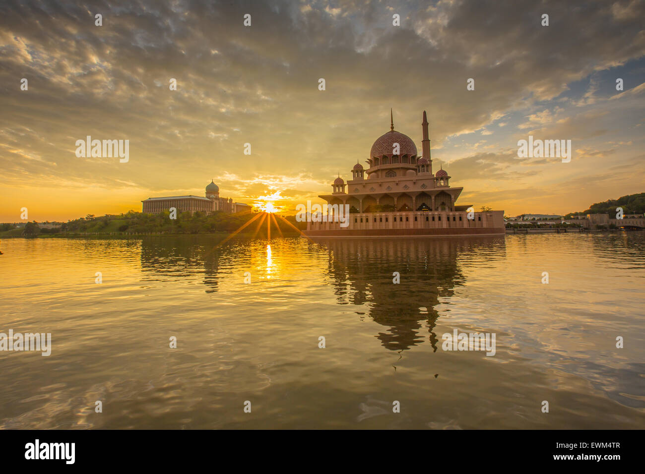 Una bellissima alba al Putra moschea, Putrajaya Malaysia che mostra le nuvole colorate, sunburst e riflessione in corrispondenza della superficie del lago Foto Stock