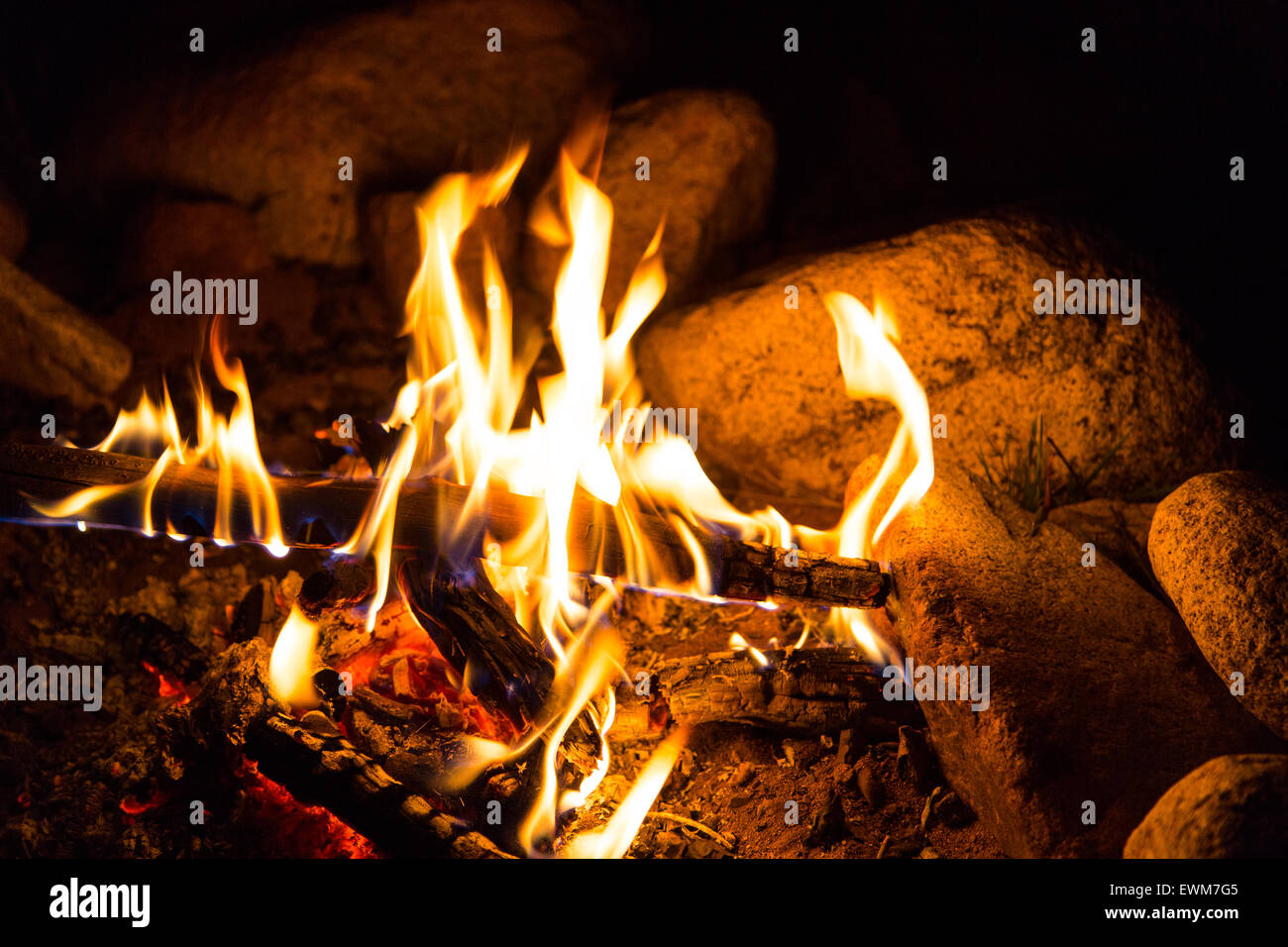 Un fuoco arde intorno a una pietra una buca per il fuoco in un campeggio di Los Padres National Forest. Foto Stock