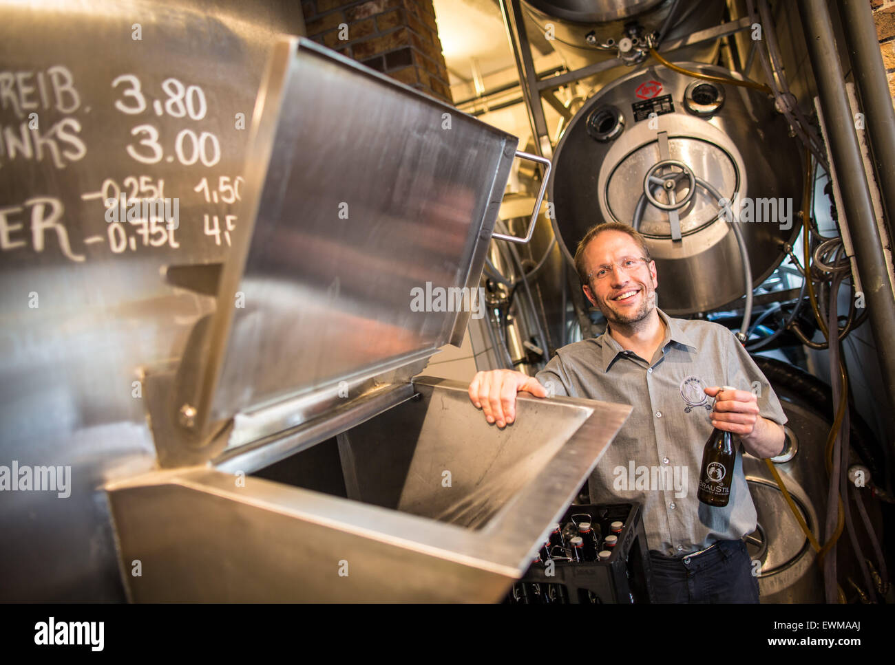 Georg Schmidt sorge in rame della birra nella sua piccola birreria "Braustil, ' si trova in un ex stazione di gas in Frankfurt am Main, Germania, 27 giugno 2015. Un numero sempre maggiore di piccole fabbriche di birra in Germania stanno rendendo le varietà che il gusto in modo diverso, anche se le grandi imprese sono anche precipitando nel business ora. Foto: FRANK RUMPENHORST/dpa Foto Stock