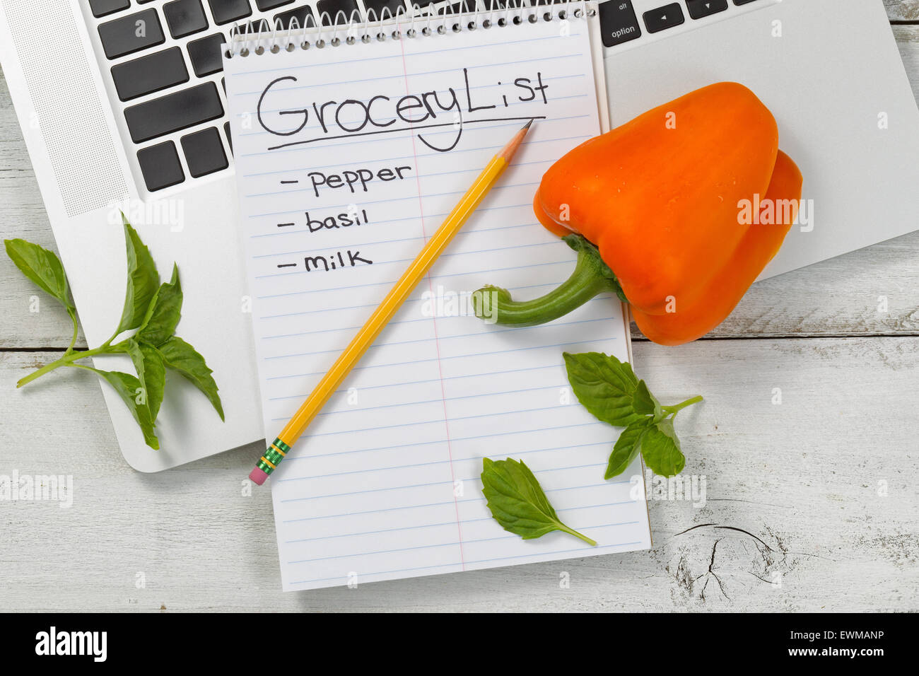 Desktop con laptop, blocco di carta, matita e prodotti freschi. On line shopping alimentare concetto. Foto Stock