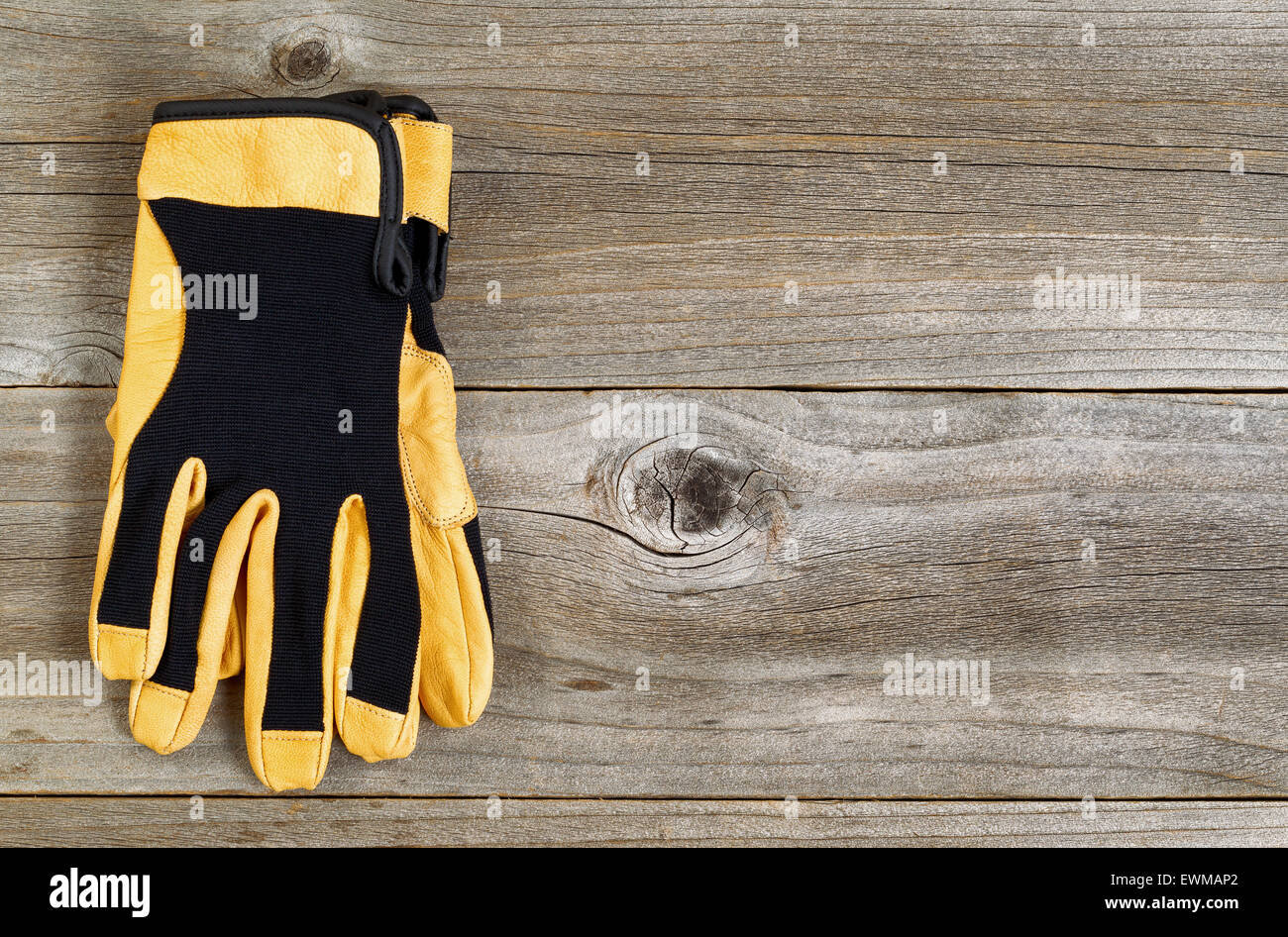 Nuovo in pelle e nylon guanti di utilità su rustiche tavole di legno. Foto Stock