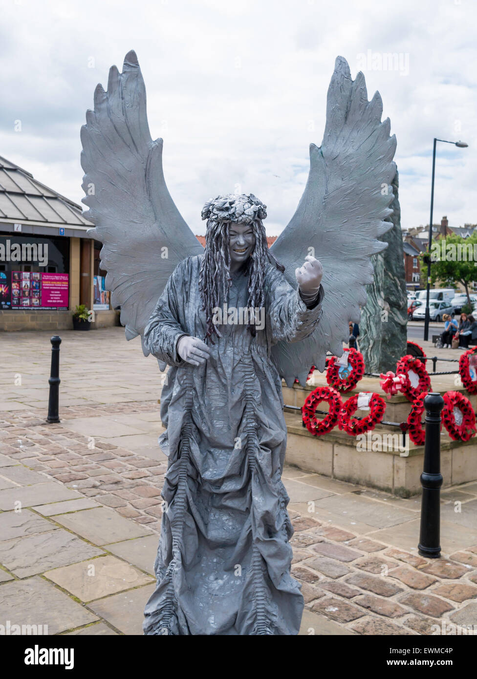 Una donna che si presentano come un molto elaborata statua vivente di un Angelo fatto cenno a Whitby North Yorkshire England Regno Unito Foto Stock