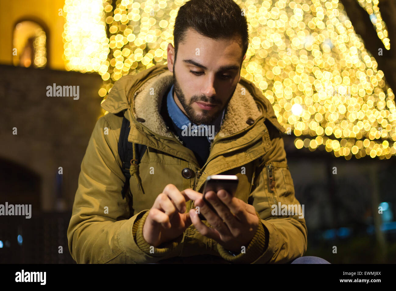 Outdoor Ritratto di giovane uomo con il suo telefono cellulare di notte. Foto Stock
