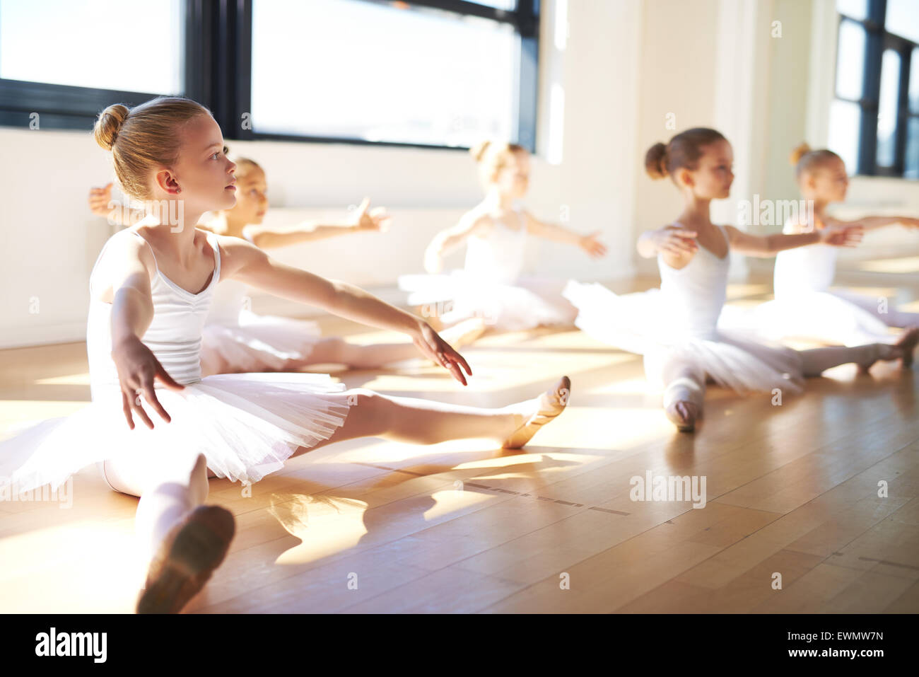 Ragazze giovani, indossando Tutus bianco, seduto sul pavimento dello studio pur avendo una formazione per il balletto di danza. Foto Stock