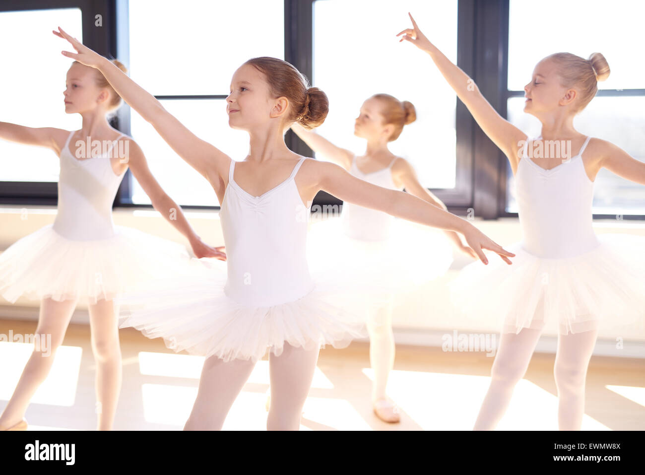 La coreografia danza di un gruppo di grazioso piuttosto giovani ballerine pratica durante la classe in un balletto classico a scuola Foto Stock