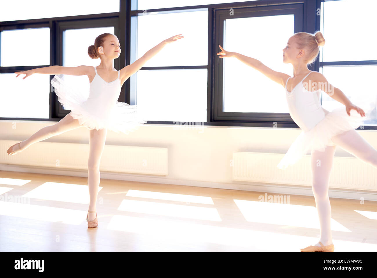 Due graziosi bambine praticando un balletto coreografato in un balletto classico studio che soddisfino i loro sogni di diventare un Foto Stock