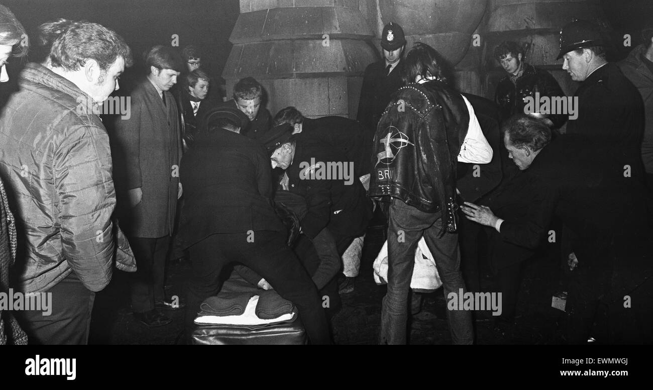 Un ferito nuovo anni reveller visto qui come ottenere il trattamento dopo la caduta dal Chamberlain Memorial a Chamberlain Square, Birmingham 31 Dicembre 1968 Foto Stock