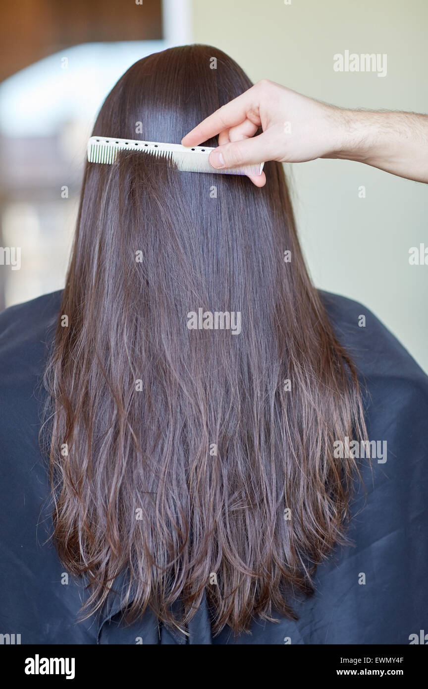 Mano con pettine donna pettinatura capelli al salon Foto Stock