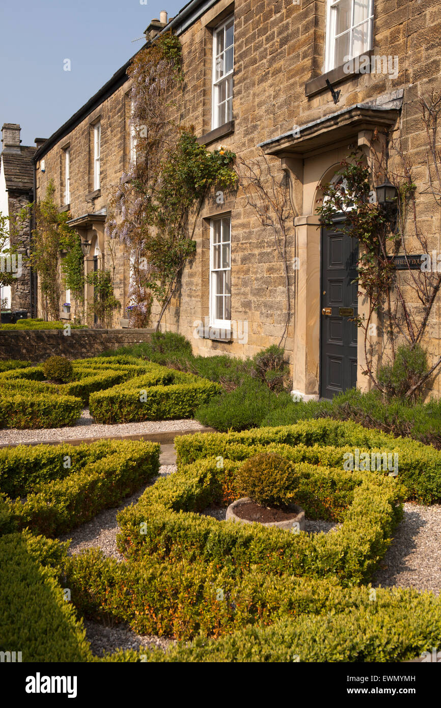 Regno Unito, Inghilterra, Derbyshire, Ashford nell'acqua, Church Street, perfettamente agganciato formale di yew siepe di bosso in giardino anteriore Foto Stock