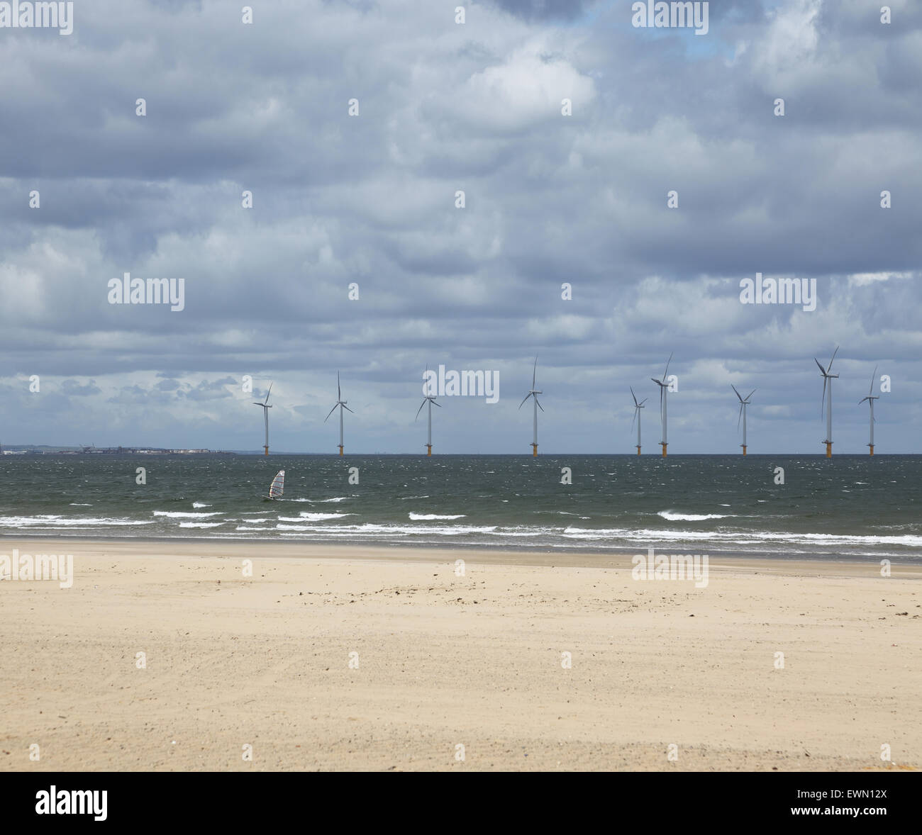 Energia eolica nel Fiume Tees estuario fotografata da Redcar beach. Windsurf in primo piano Foto Stock