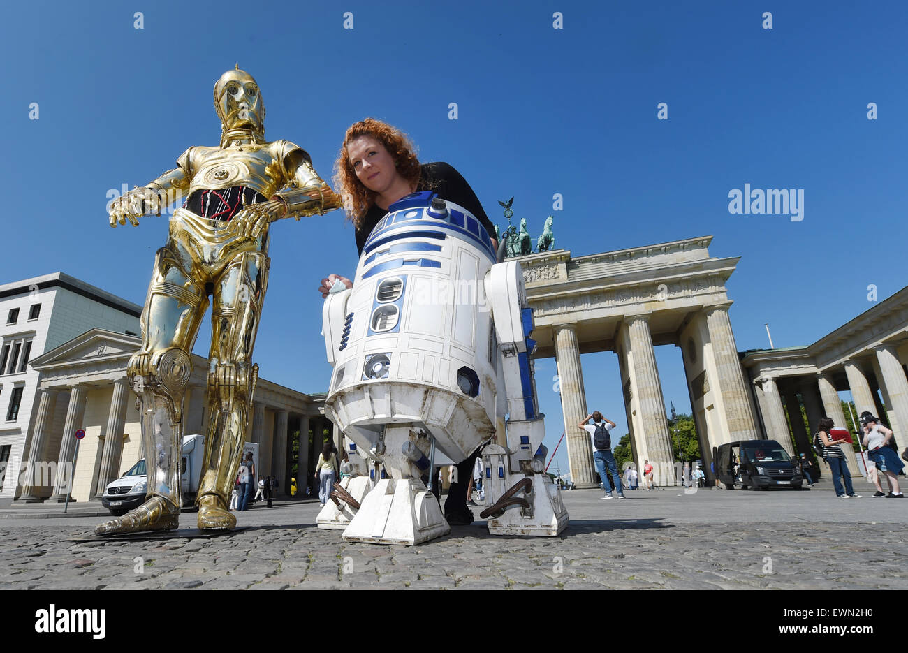 Berlino, Germania. Il 29 giugno, 2015. Project manager Nina-Kristin Zerbe (R, indietro) sorge tra le Star Wars caratteri droidi C-3PO (L) e R2-D2 di Madame Tussauds' museo della cera in piedi durante un tour di promozione di fronte alla Porta di Brandeburgo a Berlino, Germania, 29 giugno 2015. Il museo delle cere di Madame Tussauds, Disney e Lucas Films hanno forze congiunte per una stretta collaborazione per la mostra "Guerre Stellari a Madame Tussauds' che vetrine 11 caratteri, gli eroi e i cattivi della saga di Star Wars. Credito: dpa picture alliance/Alamy Live News Foto Stock