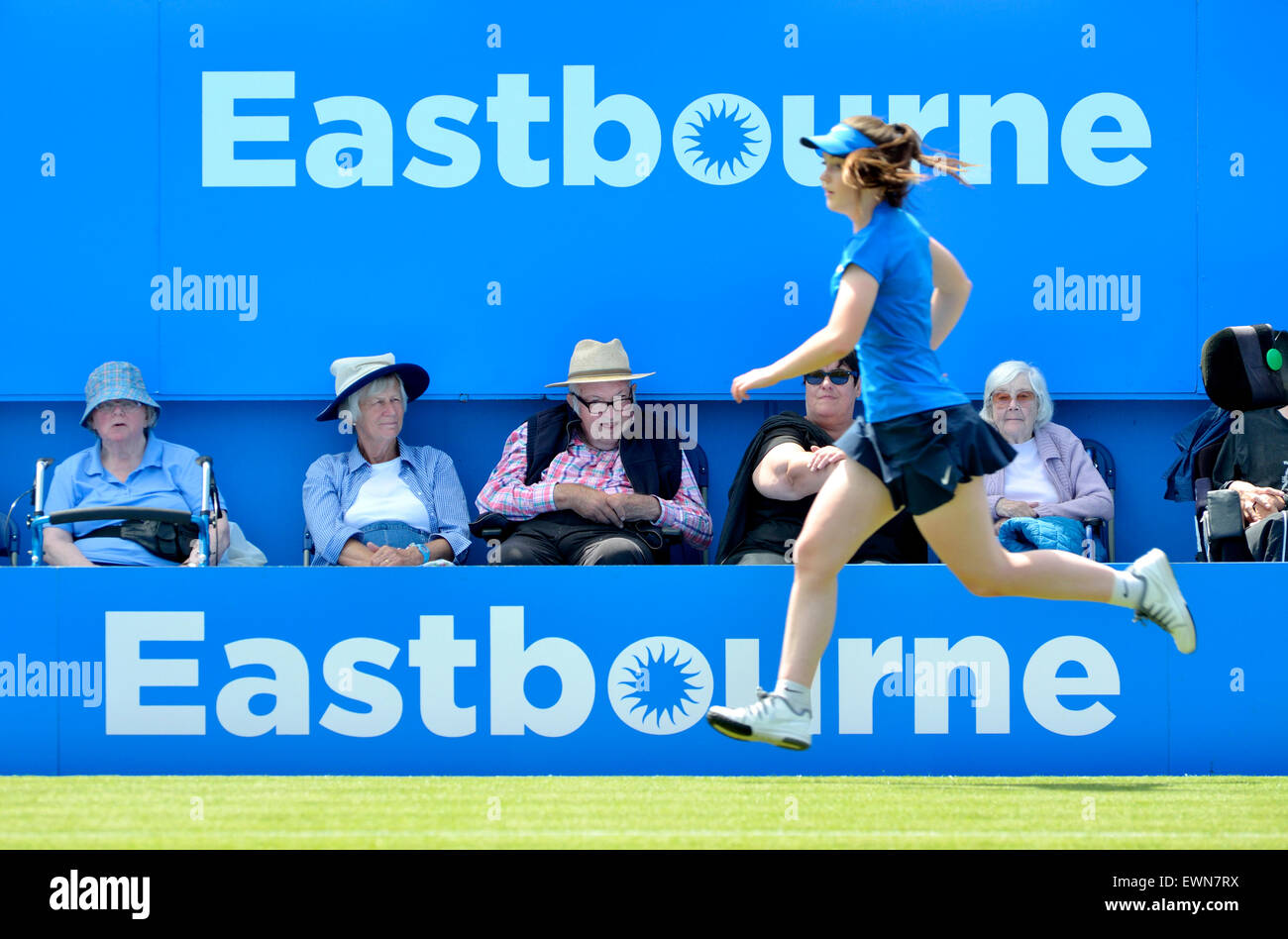 Anziani spettatori e una sfera in esecuzione ragazza sul Centre Court a Aegon torneo internazionale a Eastbourne, 2015 Foto Stock