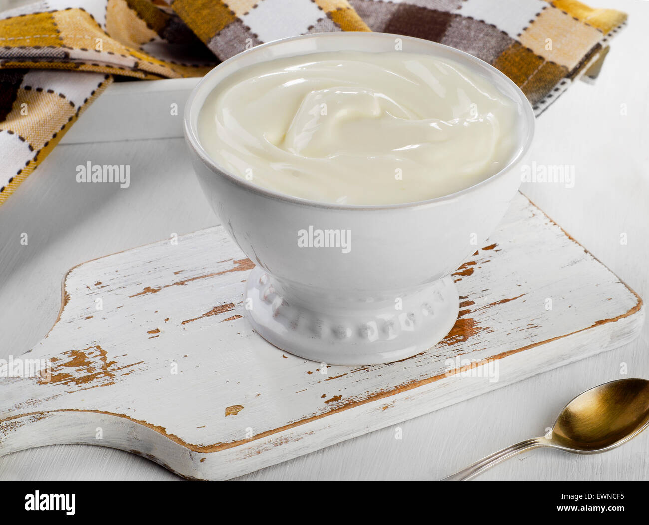 Lo yogurt greco in una ciotola bianco su un tavolo di legno. Foto Stock