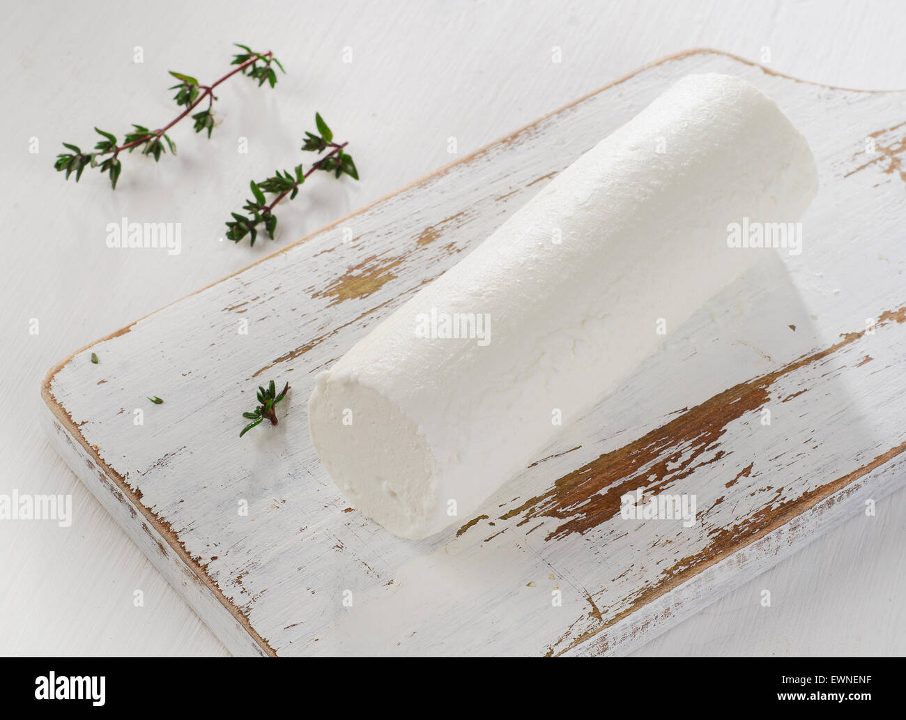Formaggio di capra con erbe fresche su bianco tavolo in legno. Foto Stock