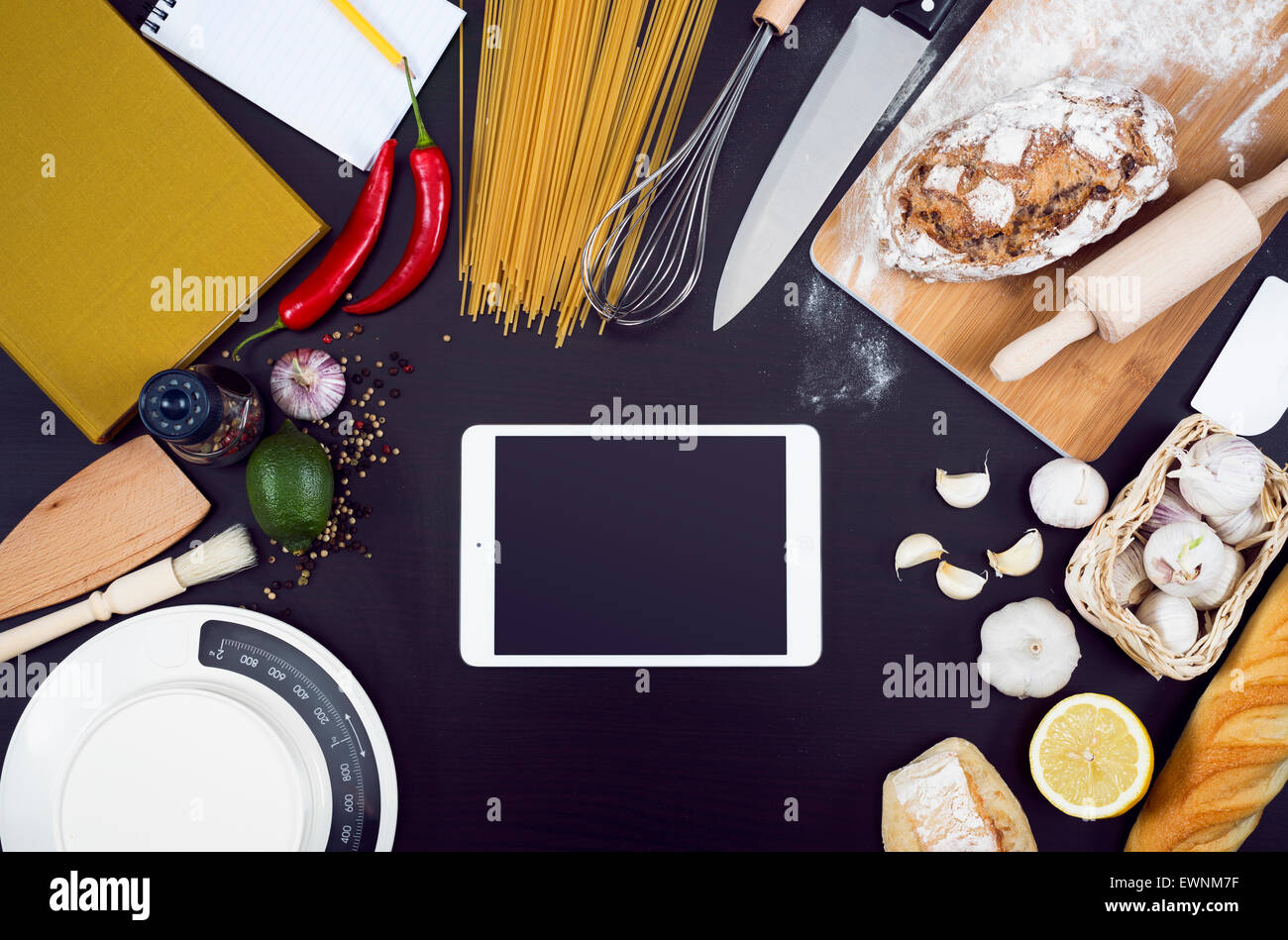 La cucina o il ristorante e il cibo hero testata. Articoli per la cucina con copia spazio su sfondo nero con i tablet pc. Foto Stock