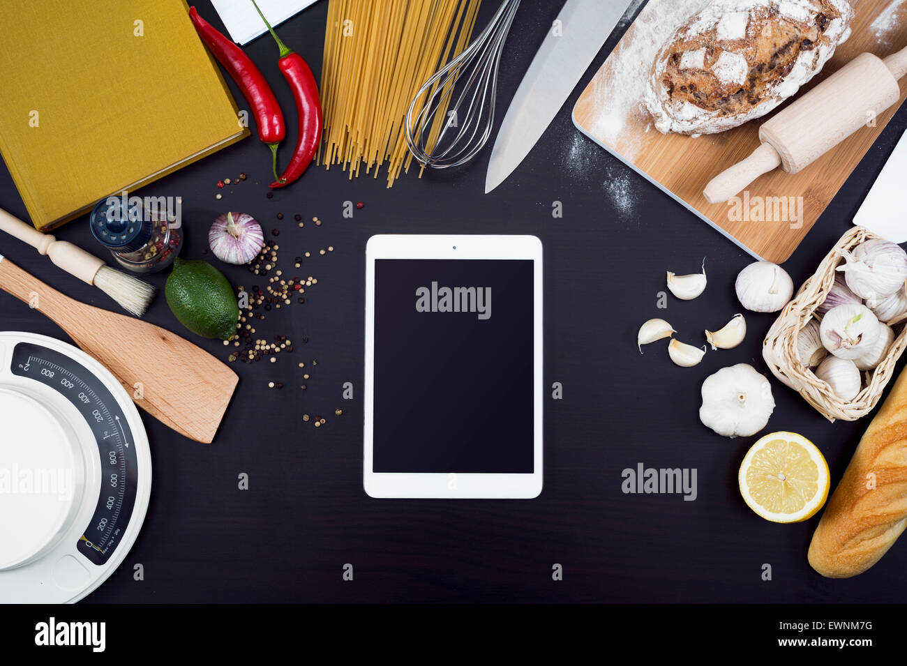 La cucina o il ristorante e il cibo hero testata. Articoli per la cucina con copia spazio su sfondo nero con i tablet pc. Foto Stock