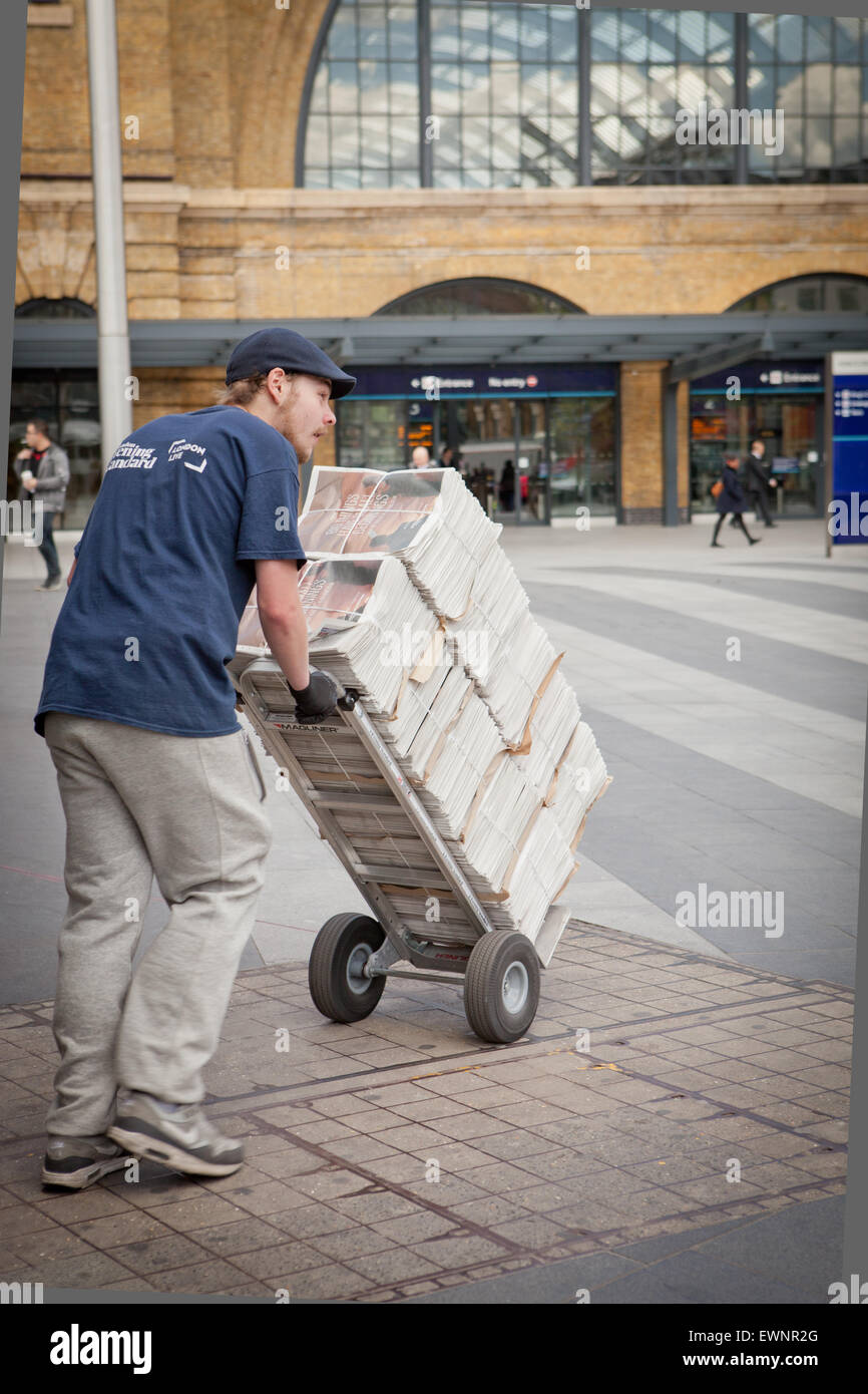 Uomo con carrello offrendo Evening Standard quotidiani Foto Stock
