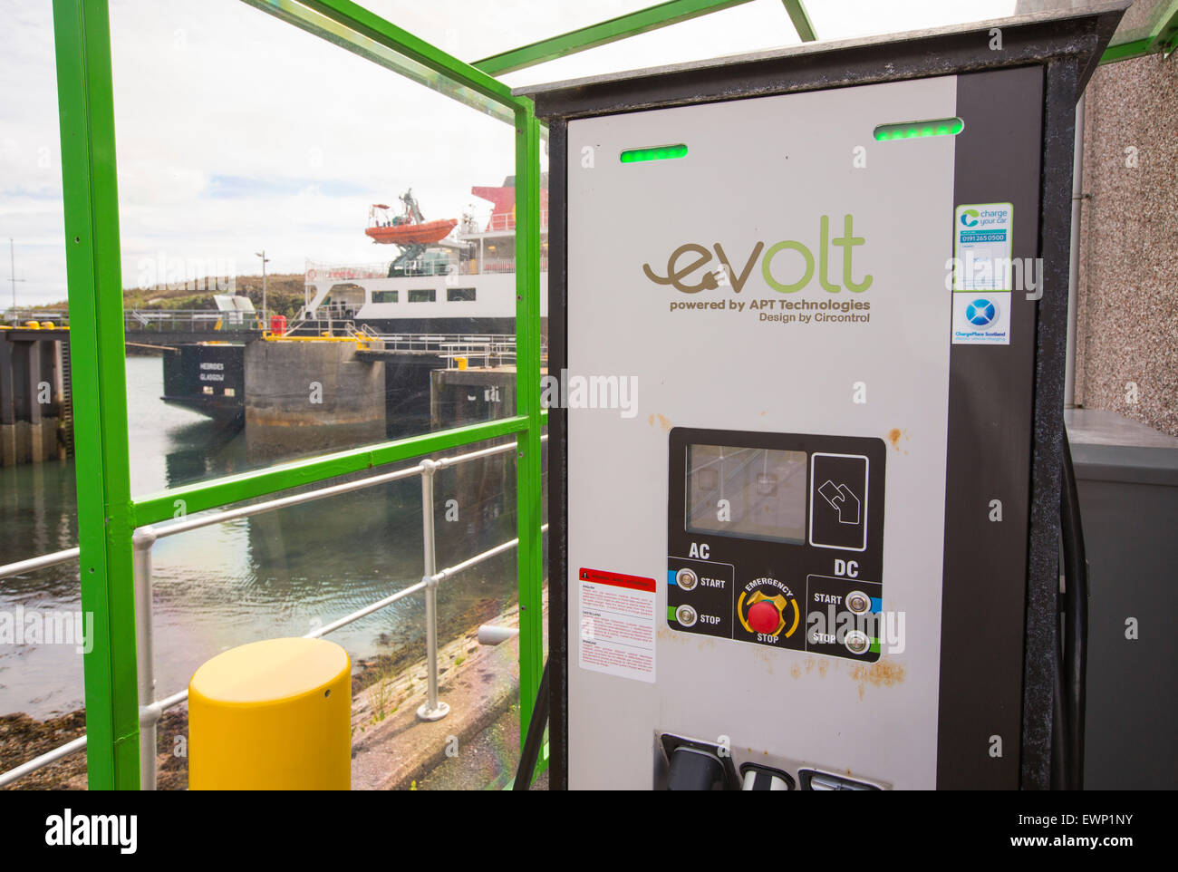 Un veicolo elettrico stazione di carica a Tarbert sull'Isle of Harris, Ebridi Esterne, Scozia, con il traghetto in background. Foto Stock