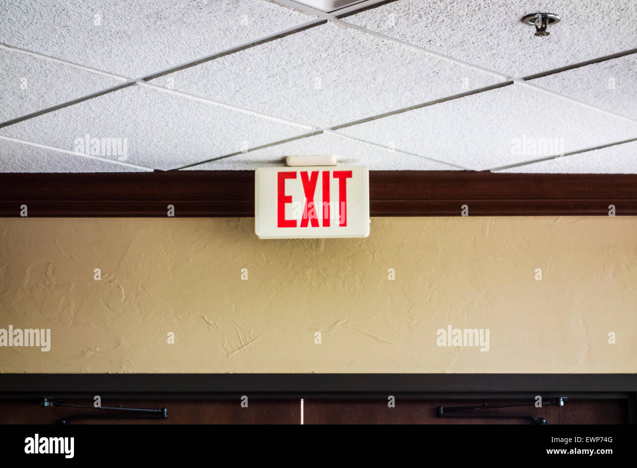 Un segnale di uscita il cui soffitto incontra la parete. Inoltre mostrando è un fuoco ugello irroratore. Stati Uniti d'America Foto Stock