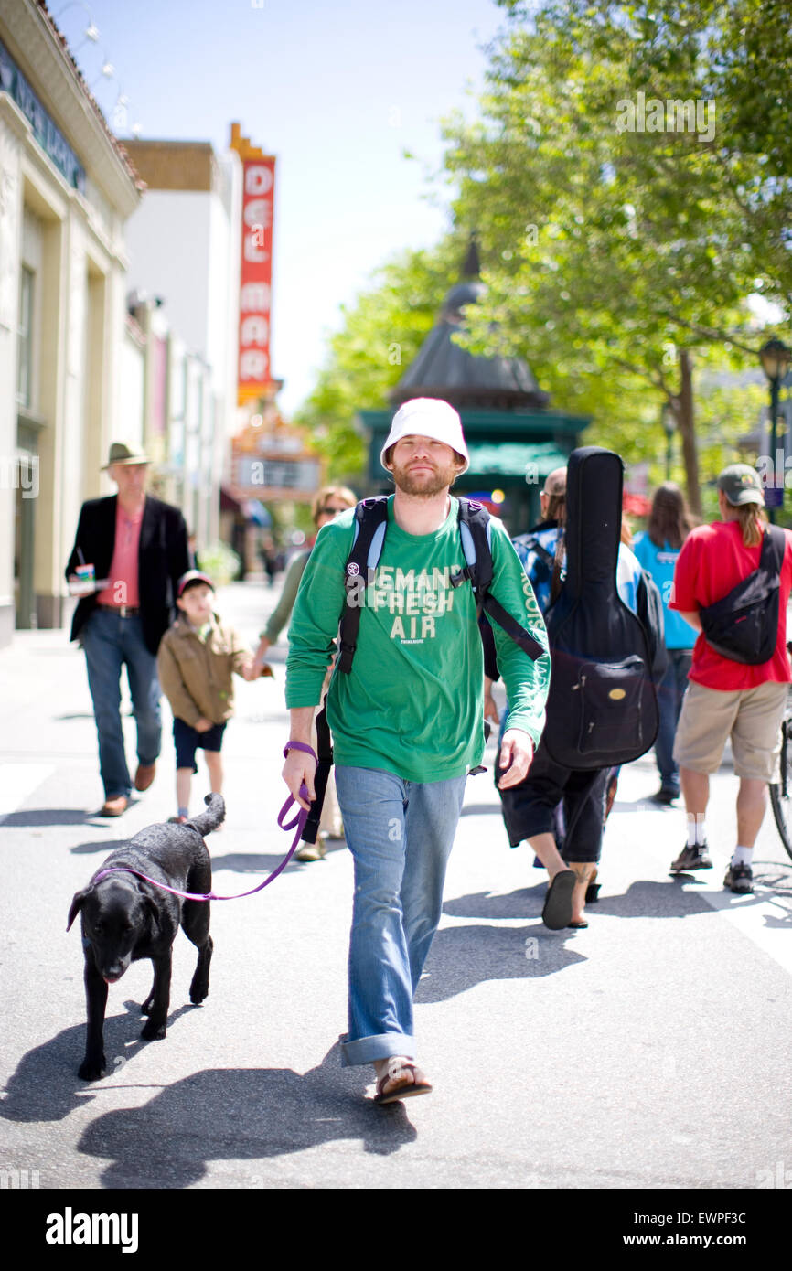 Un uomo cammina un cane sulla piccola strada di città a Santa Cruz, in California. Foto Stock