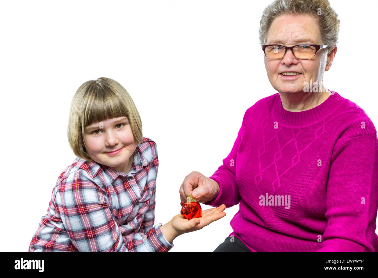 Nonna caucasica mettendo euro moneta in nipote di salvadanaio per il salvataggio di isolati su sfondo bianco Foto Stock
