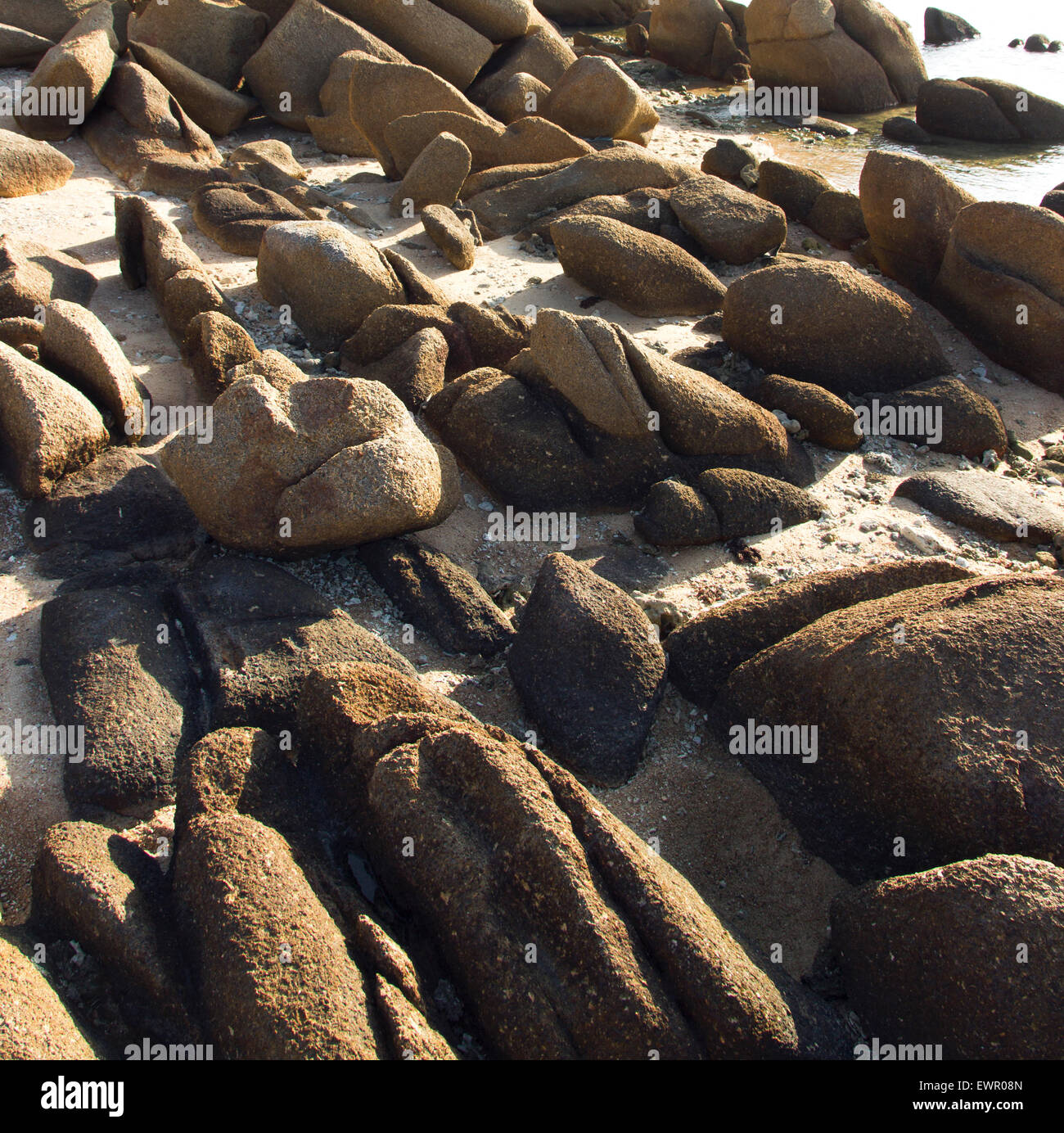 Pietre e sabbia sulla spiaggia del mare. costa sullo sfondo Foto Stock