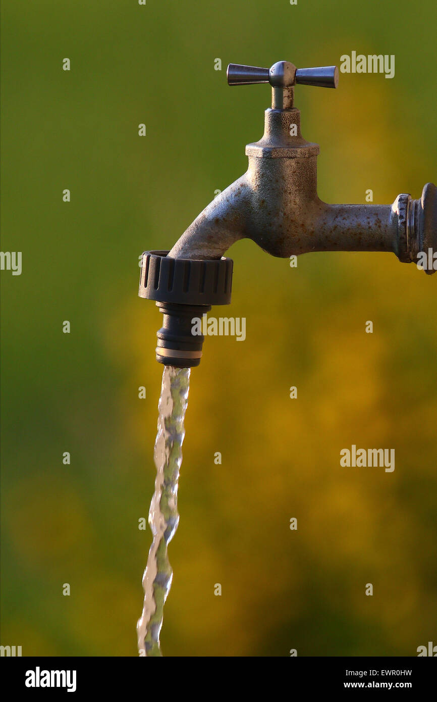 Acqua fresca pulita la fuoriuscita di un rubinetto con un sfondo colorato Foto Stock Acqua fresca pulita la fuoriuscita di un rubinetto con un sfondo colorato Foto Stock