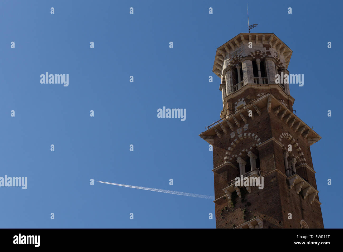 Una vista della Torre dei Lamberti con un aereo che attraversano il cielo, Verona, Italia Foto Stock