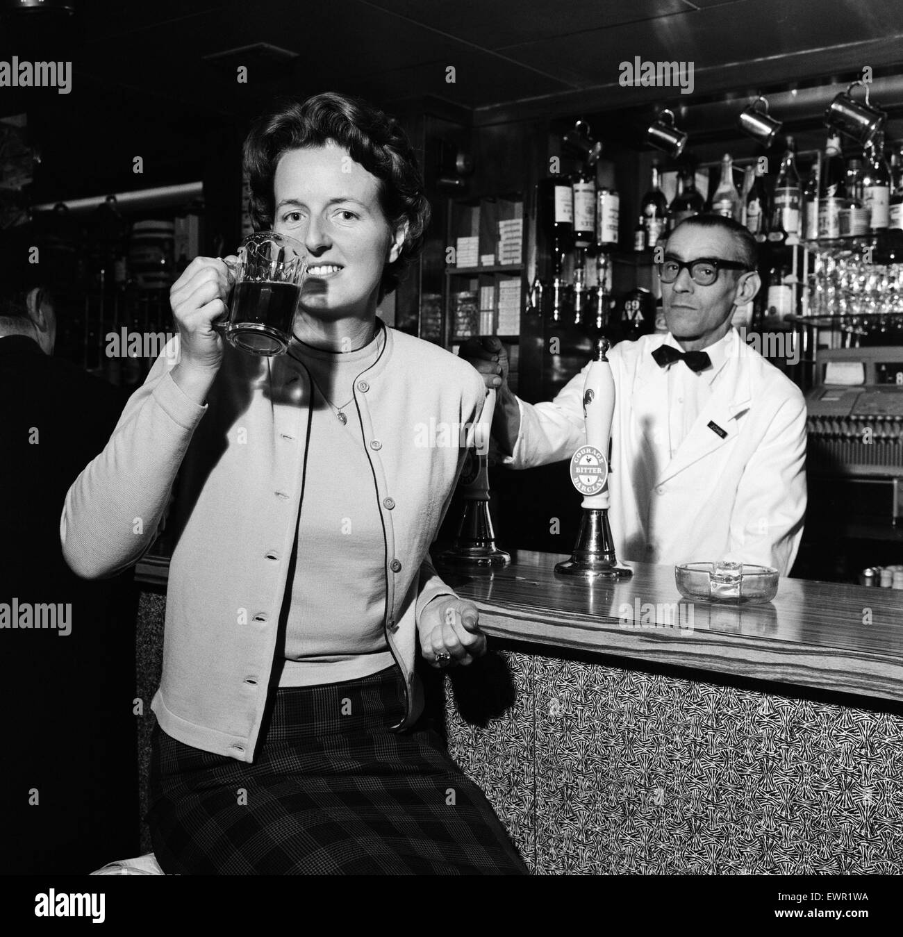 Daily Mirror fotografo Doreen Spooner bere birra per una funzione in Daily Mirror. Il 27 settembre 1962. Foto Stock