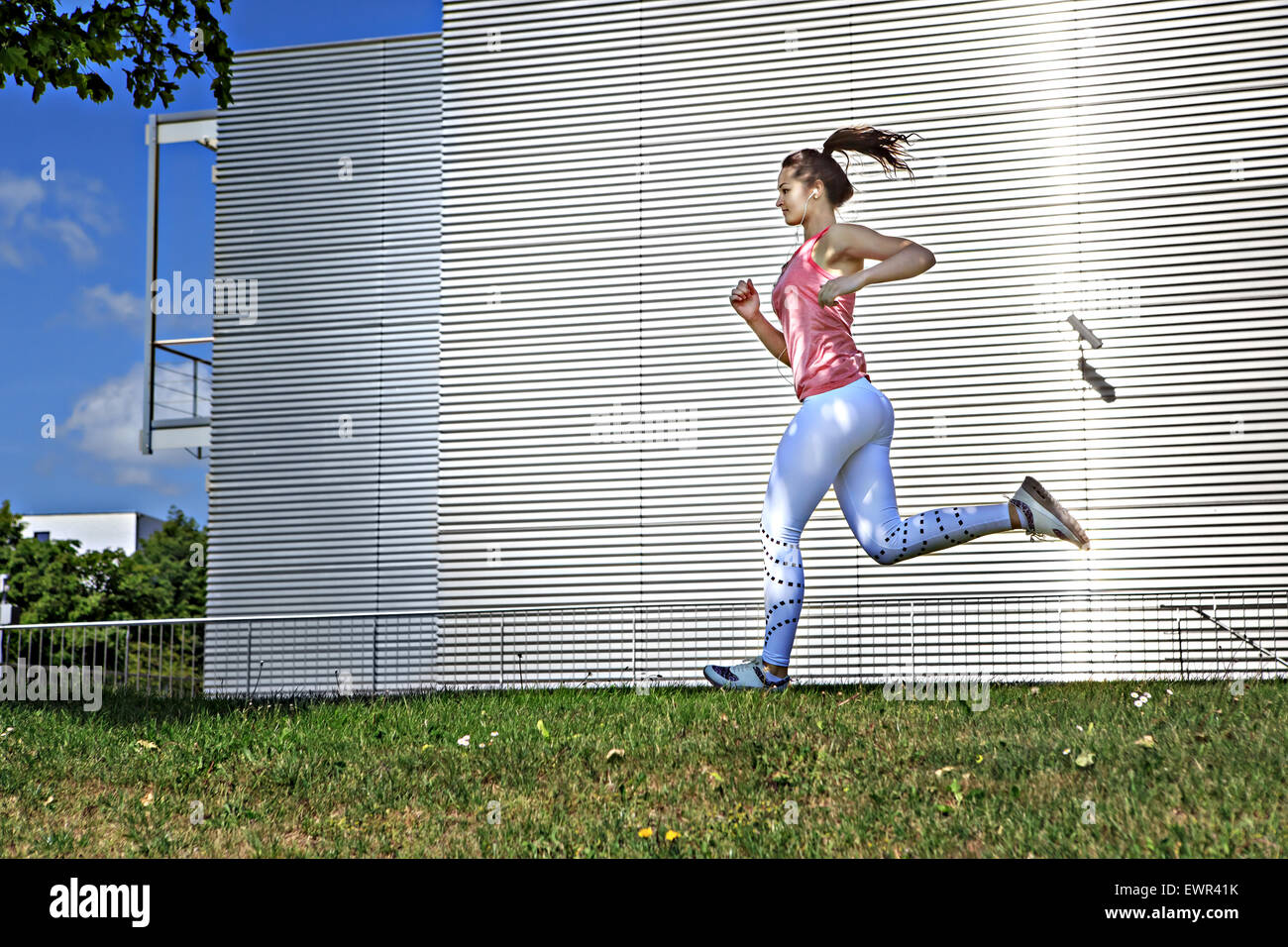 Una giovane donna jogging in città Foto Stock