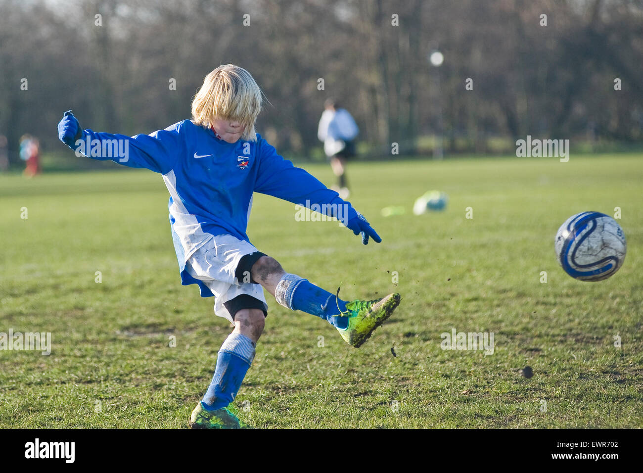 Un giovane ragazzo gioca a calcio a Londra per la sua squadra locale Foto Stock